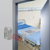 Secure Wireless Alarm Monitor mounted on the wall outside of the patient room. The wireless bed sensor pad is on the hospital bed in the room.