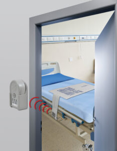 Secure Wireless Alarm Monitor mounted on the wall outside of the patient room. The wireless bed sensor pad is on the hospital bed in the room.