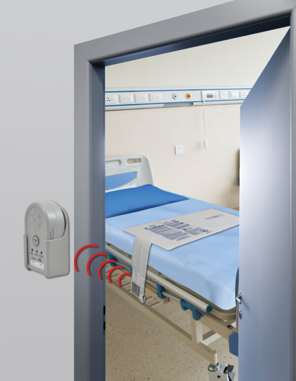 Secure Wireless Alarm Monitor mounted on the wall outside of the patient room. The wireless bed sensor pad is on the hospital bed in the room.