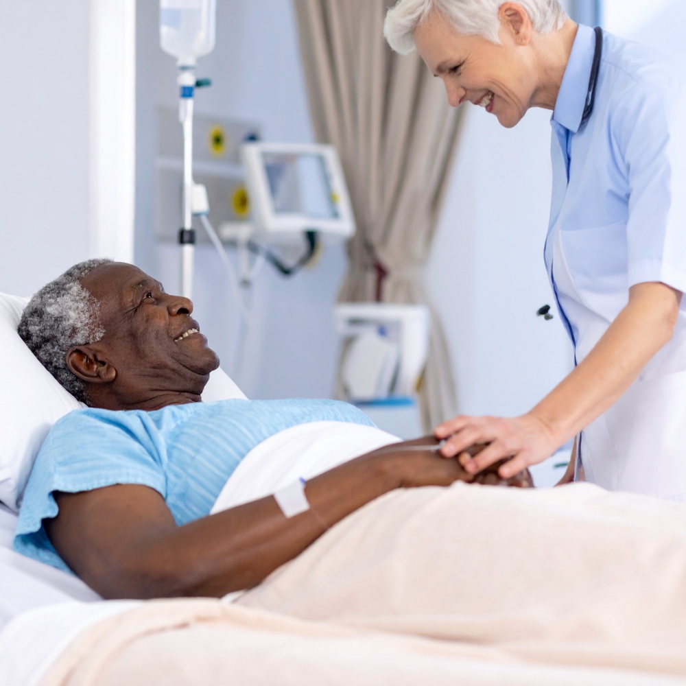 Nurse Helping Eldelry Man In Bed